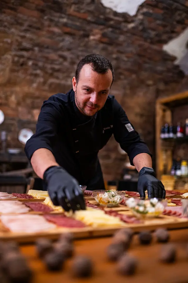 Branding photography of chef in action preparing fine dining dish in professional kitchen in Sibiu, showcasing culinary skill and craftsmanship.
