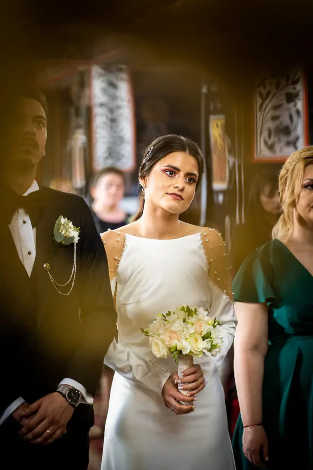 Bride participating in a religious wedding ceremony, captured with soft natural light.