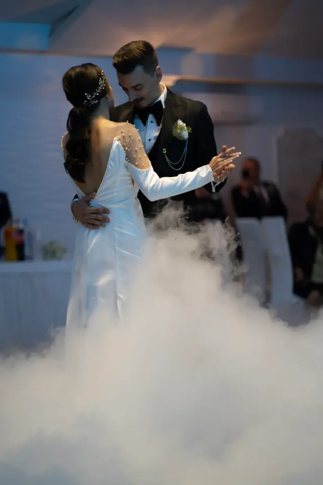 Bride and groom dancing joyfully at their wedding celebration.