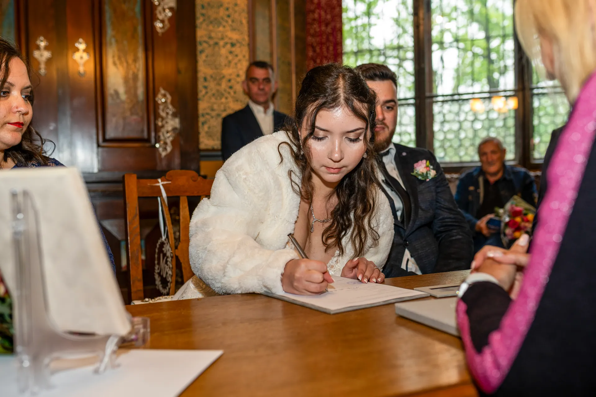 Bride signing at the registry office in the Mutterturm, the groom beside her