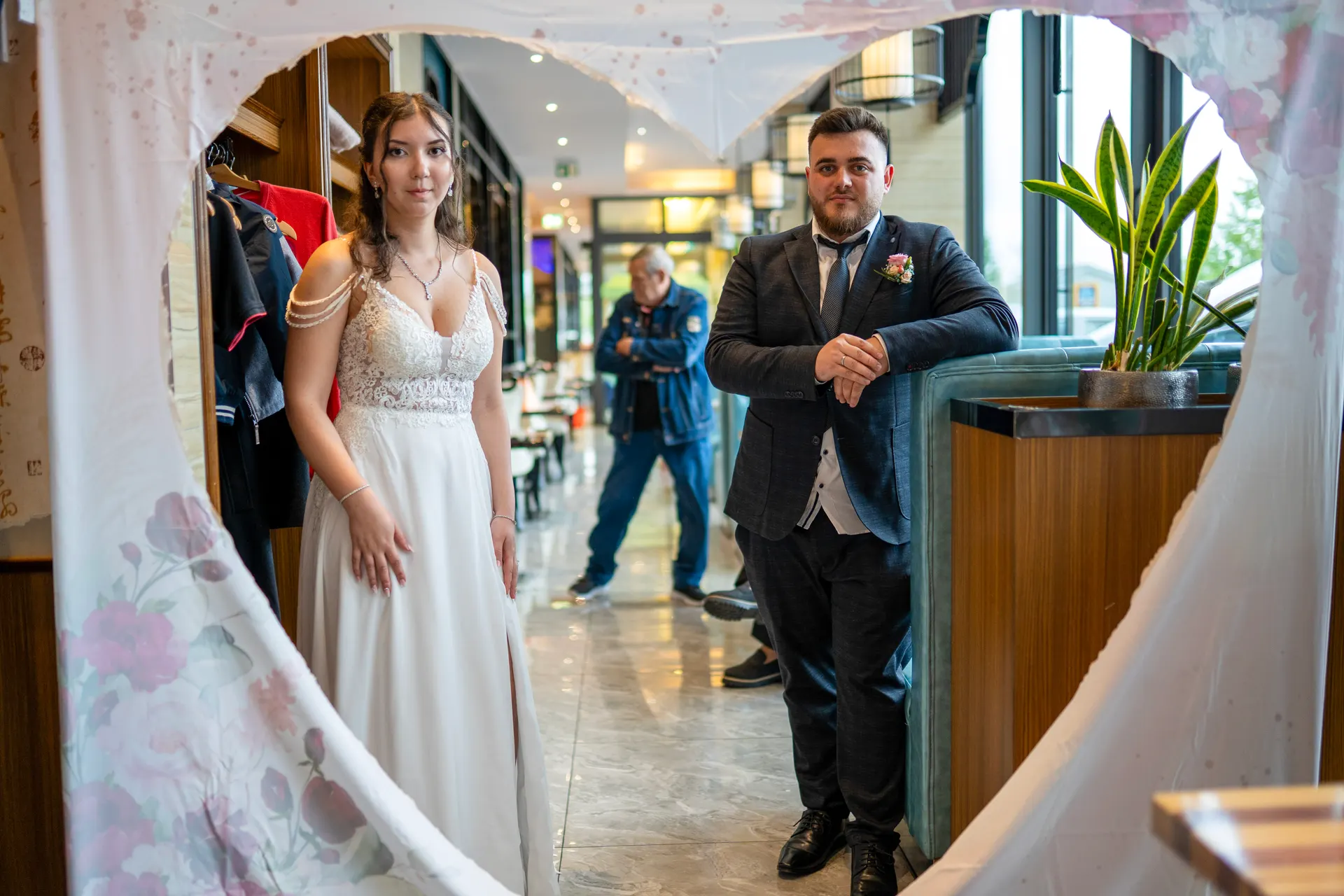 Bride and groom in the restaurant, framed by a heart-shaped cut-out in a fabric drape