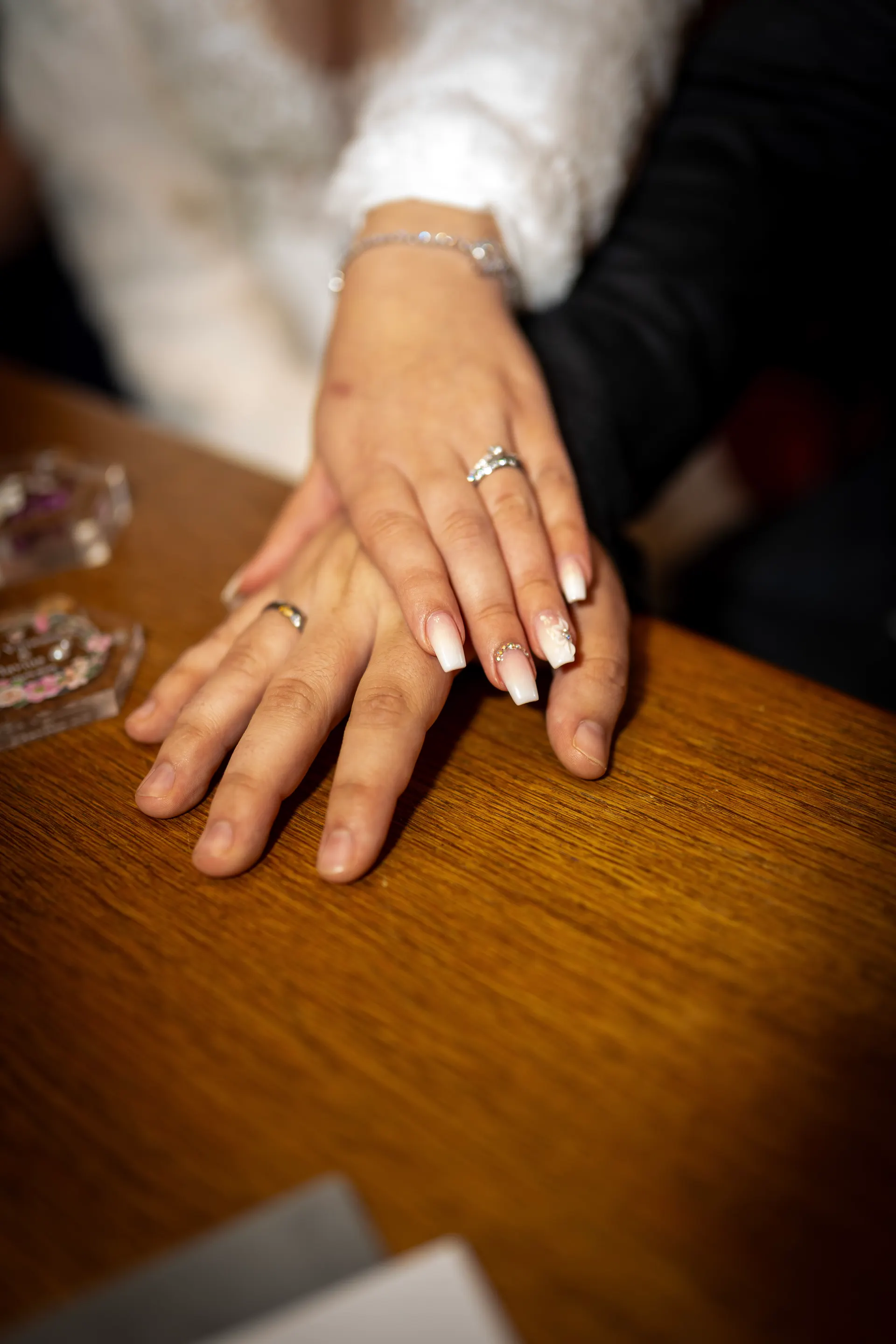 The couple’s hands with wedding rings on the registry office table